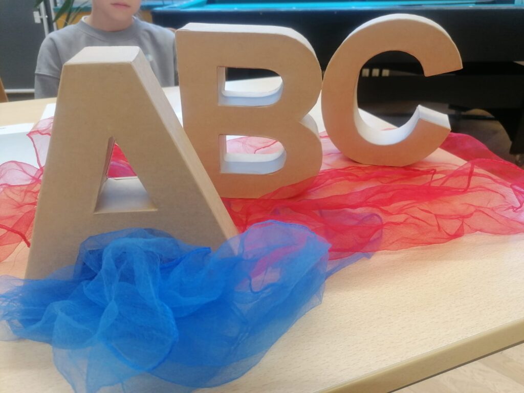 A. B und C als Holzbuchstaben auf einem Holztisch.