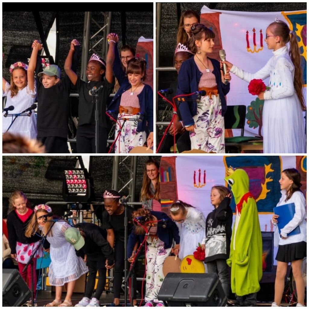 Kinder freuen und Bedanken sich beim Publikum nach einer Aufführung auf der Bühne.