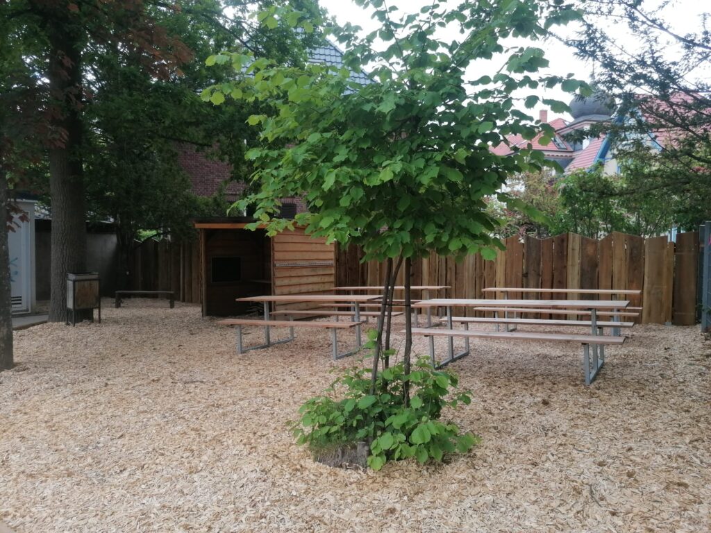 Der neue Park mit Bänken einer kleinen Hütte und einem kleinen Baum.