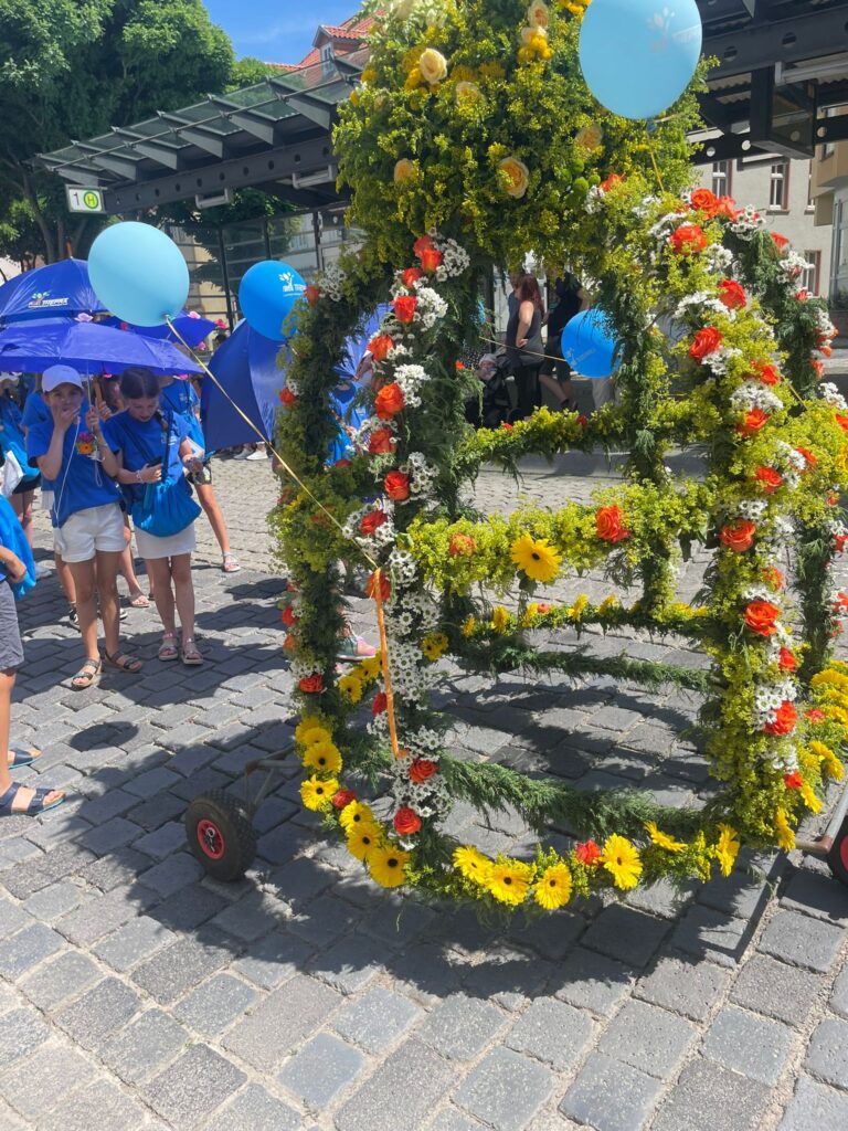 Umzugswagen aus Blumen und blauen Luftballons.
