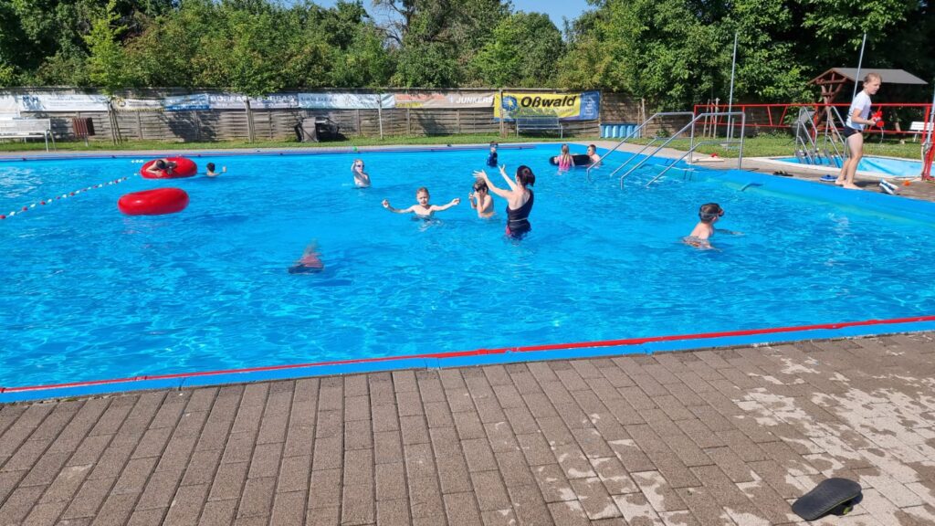 Kinder in einem Becken im Freibad.