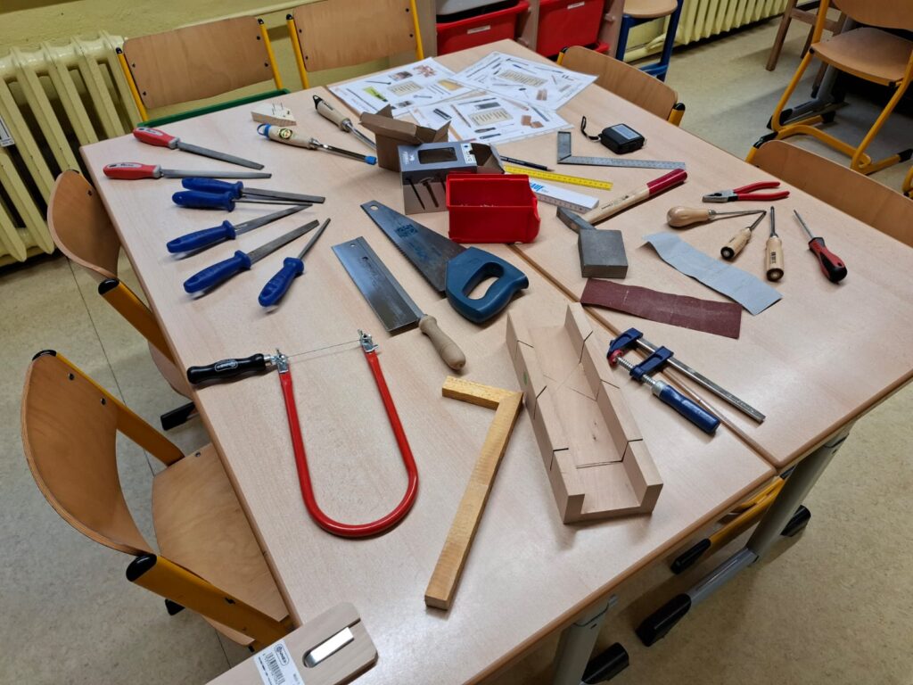 Tisch voll mit Sägen, Feilen und anderen Werkzeugen