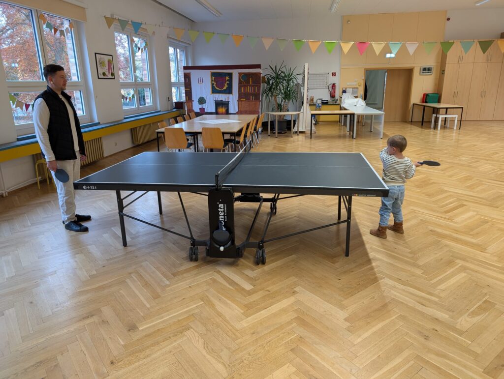 Mann spielt mit einem Jungen Tischtennis